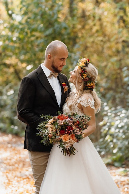 Walk of the bride and groom through the autumn forest