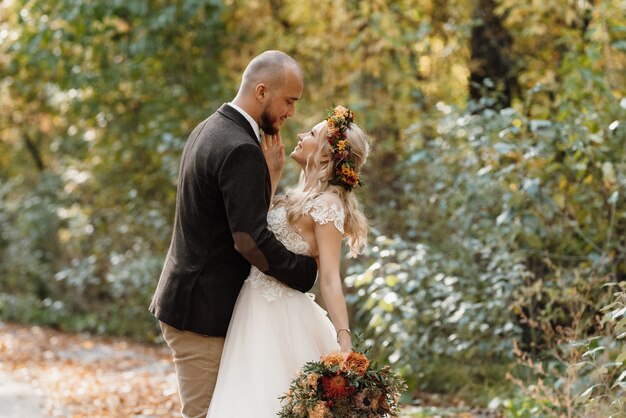 Walk of the bride and groom through the autumn forest