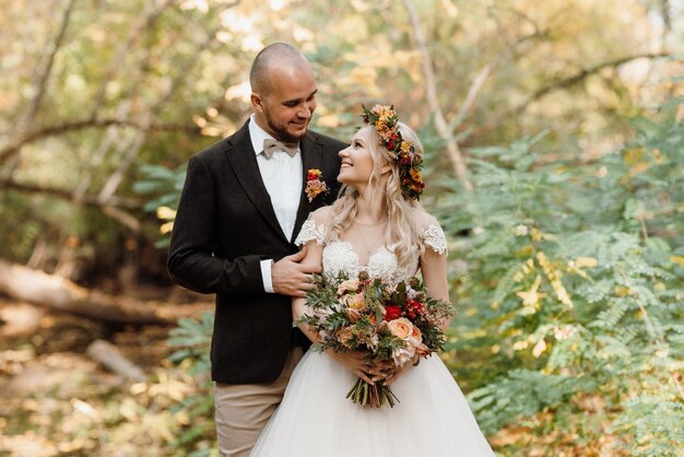 Walk of the bride and groom through the autumn forest