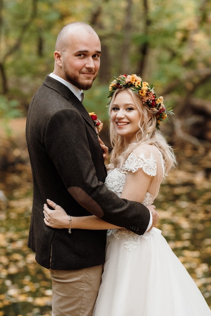 Walk of the bride and groom through the autumn forest