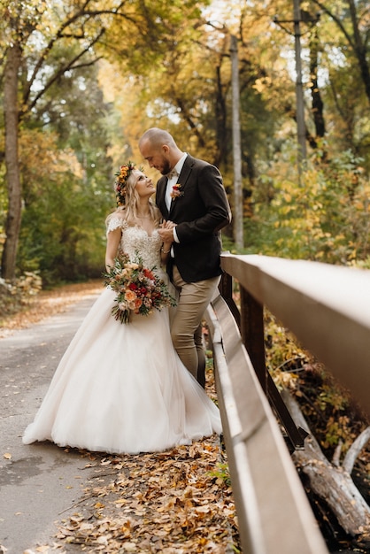 Walk of the bride and groom through the autumn forest