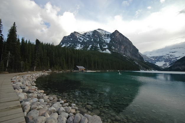 Cammino vicino al lago incontaminato e montagna di neve