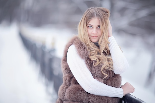 Walk in a winter park christmas girl / beautiful model posing
in the winter season walk city park