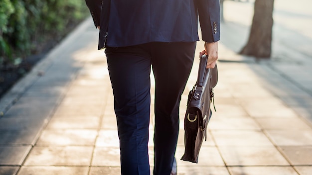 Walking business man holding his bag