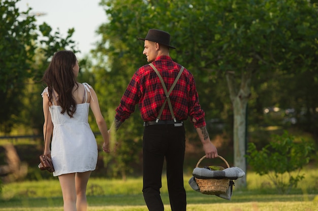 Walking down. Caucasian young and happy couple enjoying weekend together in the park on summer day