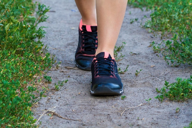 Walking female legs in sneakers