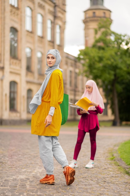 Walking to friend. International muslim woman wearing hijab walking to her friend