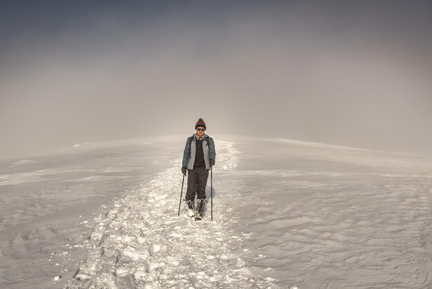 Walking hiker tourist in winter mountains