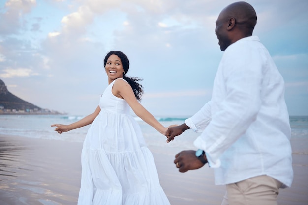 walking honeymoon and black couple holding hands at beach for support trust or travel together on date smile sea and people romantic anniversary for holiday or marriage commitment in mauritius