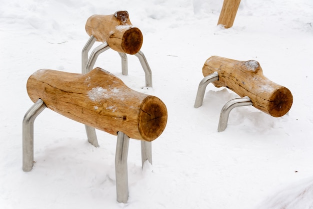 Registri a piedi. interessanti panchine a forma di animali insoliti in legno nella neve. panche a forma di pecora. paesaggio invernale.