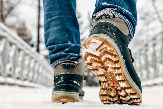 눈 속에서 걷기. 겨울 신발의 근접 촬영