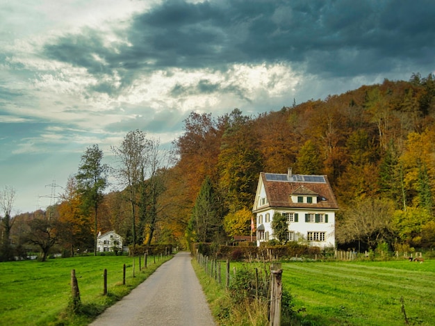 Walking trail with houses going to the mountains and forests on a cloudy day