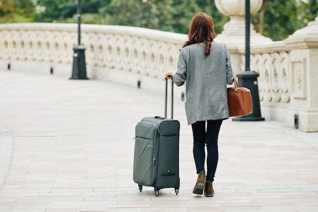 Photo walking woman with big suitcase