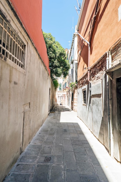 Walkway amidst buildings against sky