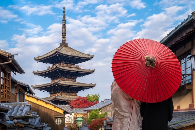 京都の伝統的な家と八坂の塔の背景を持つ古い市場の通路