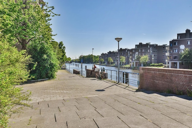 A walkway next to a river in a city