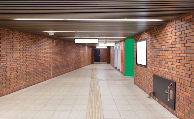 Photo walkway with brown brick wall to subway station