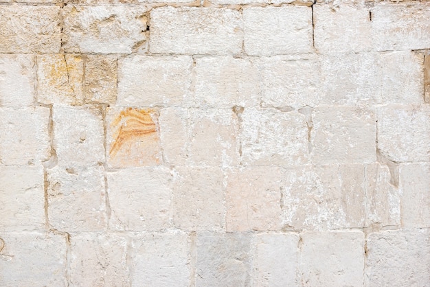 Wall of ancient building made with bricks on city street