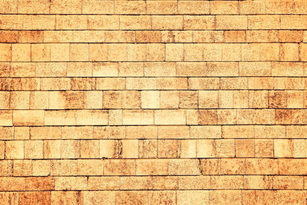 Wall of beige brick texture Toned