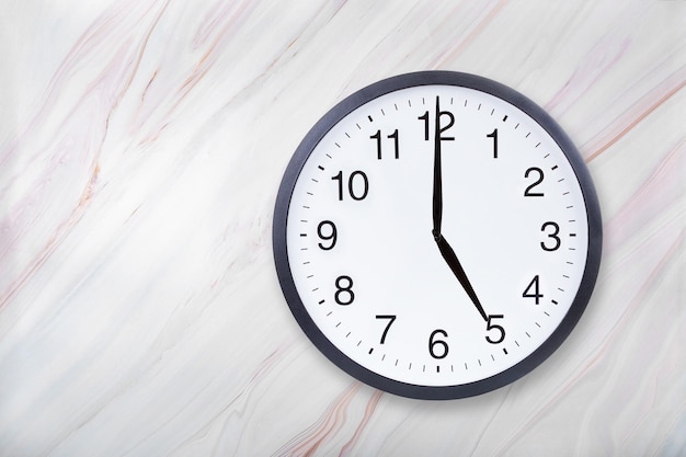 Wall clock show five o'clock on marble texture Office clock show 5pm or 5am