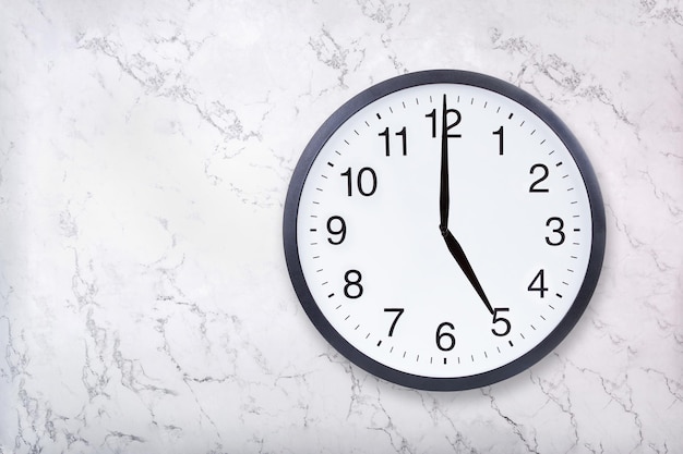 Wall clock show five o'clock on white marble texture Office clock show 5pm or 5am