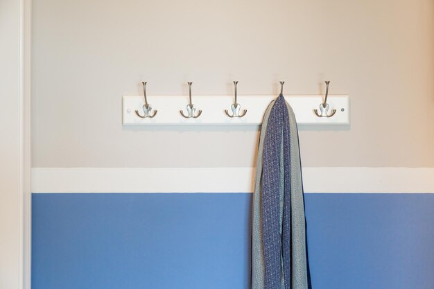 Foto parete in casa con la sciarpa appesa ai ganci del supporto per i cappotti abstract
