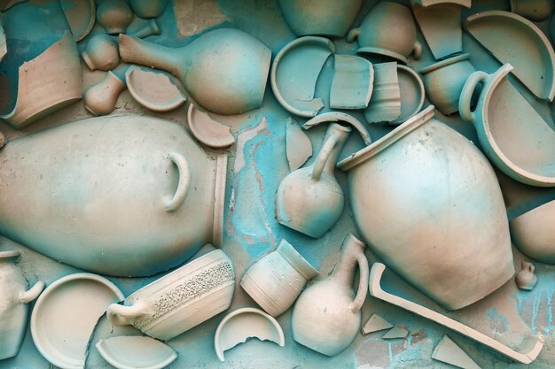 A wall is decorated by clay tableware and painted in a blue color