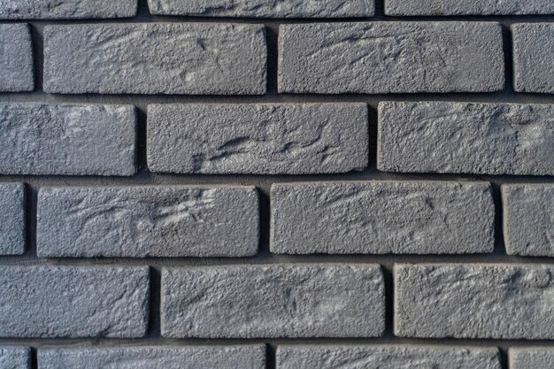 Wall is made of gray bricks Abstract background Rough textured surface Grunge or loft style