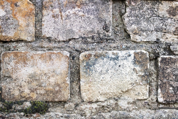 The wall is made of old dirty white brick