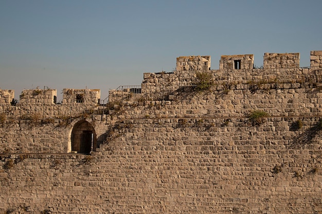 The wall of Jerusalem is tiered against a blue sky