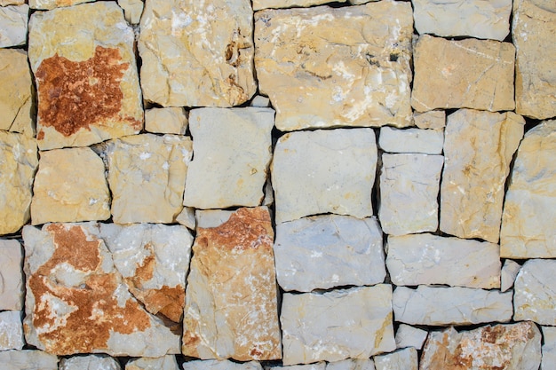 Wall of large square yellow stones, stacked blocks