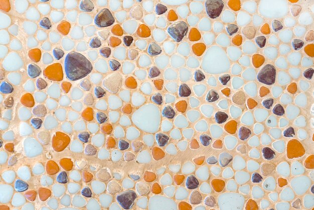 Wall lined with white orange and brown circular stones background texture