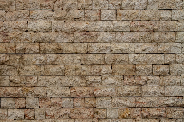 A wall made of stone blocks with a sign saying that it is a wall.