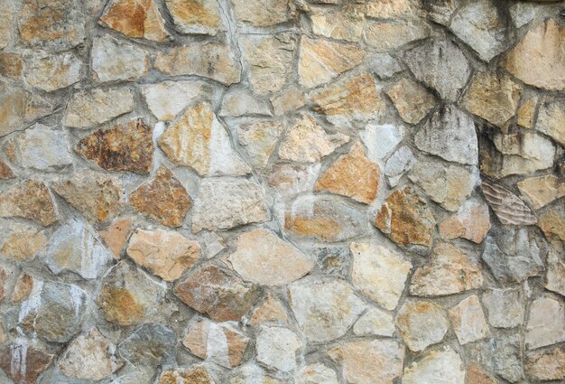 A wall made of stones with a rough textured surface.