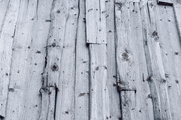 Wall of the old gray boards damaged by climate Vintage wood background Rough work