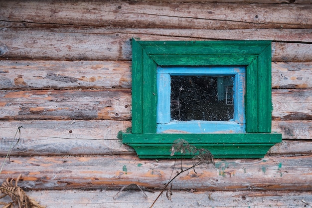 A wall of old logs with a window