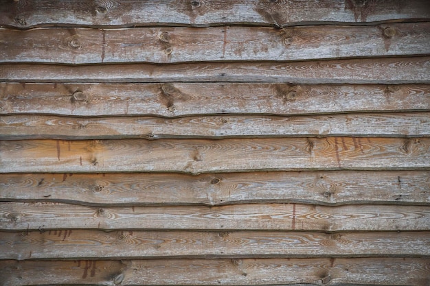 A wall of old planks stacked one on top of the other in a cascade