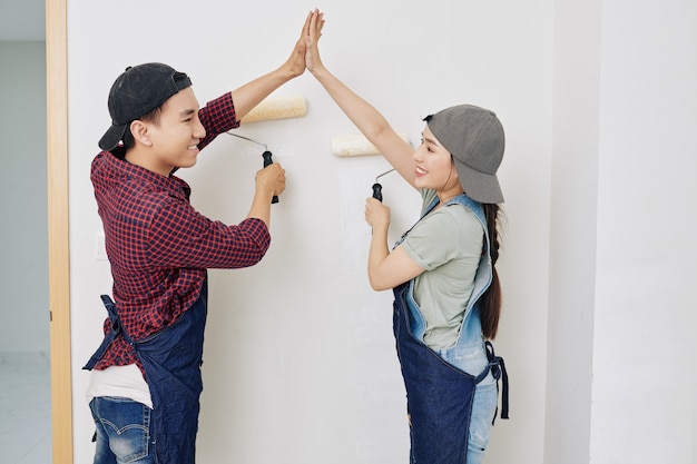 Wall painters giving high five