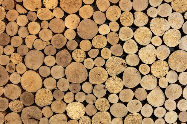 Wall of stacked wooden logs as background