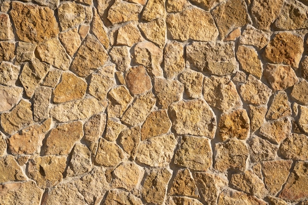 Wall of stones in the sun, background