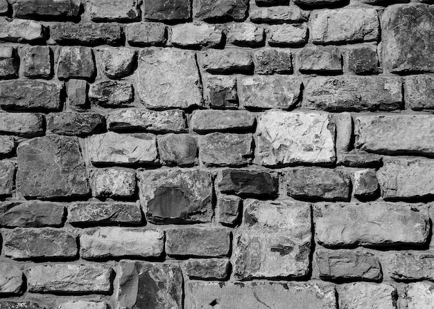 A wall of stones that are stacked in black and white