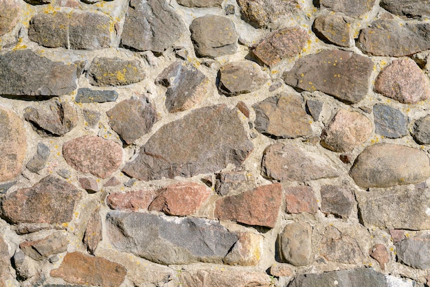 A wall of uneven stones Vintage building stone background