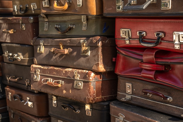 Wall of vintage suitcases stacked in a heap.