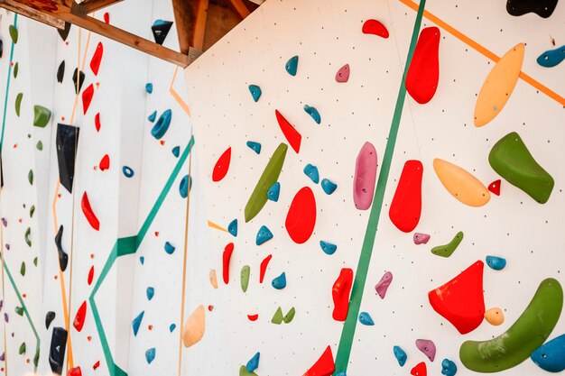 wall with climbing holds in gym practicing rockclimbing on a rock wall outdoor xtreme sports and bouldering concept rock climber climbs on a rocky wall