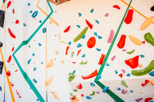 Wall with climbing holds in gym Practicing rockclimbing on a rock wall outdoor Xtreme sports and bouldering concept rock climber climbs on a rocky wall