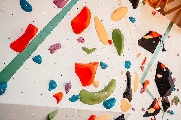 wall with climbing holds in gym practicing rockclimbing on a rock wall outdoor xtreme sports and bouldering concept rock climber climbs on a rocky wall