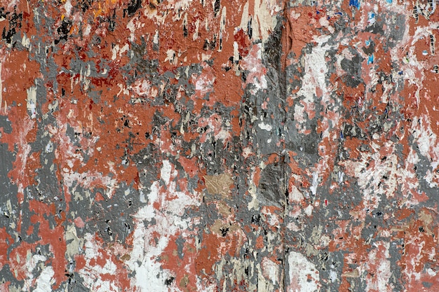 Wall with traces of old peeling paint, torn paper and glue background.