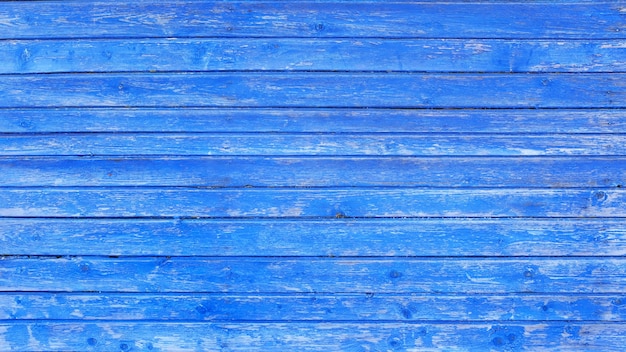 Wall of wooden boards with old blue paint. background for design