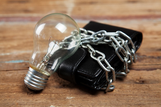 Wallet in chains and a light bulb on the table