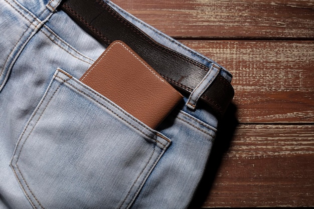 Wallet from the back pocket of jeans on a wooden background